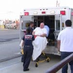 emergency medical technician putting patient in ambulance