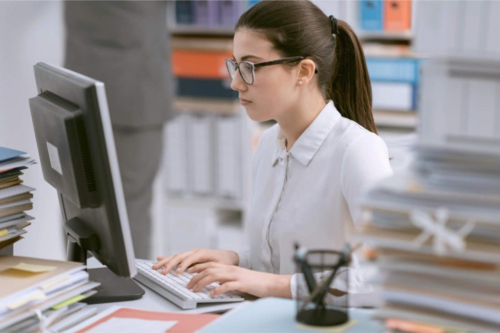 A data clerk, using her computer, focused on her work.
