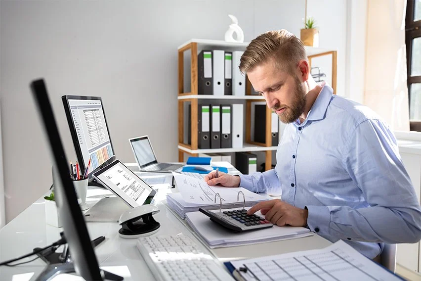 An accountant man checking the compiled ledgers to prepare the income statement and balance sheet.